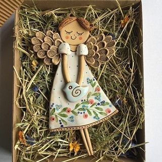 an angel figurine in a box with straw