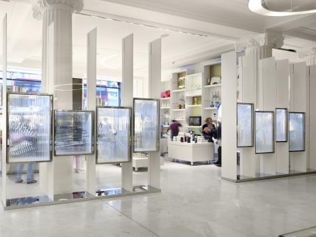 a group of people are standing in a room with mirrors on the wall and pictures on the floor