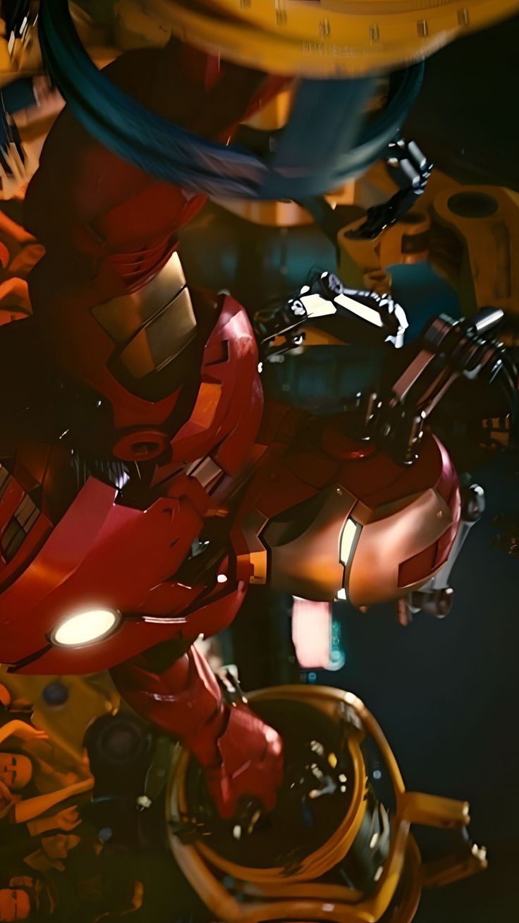 a red robot standing in front of some yellow and blue objects