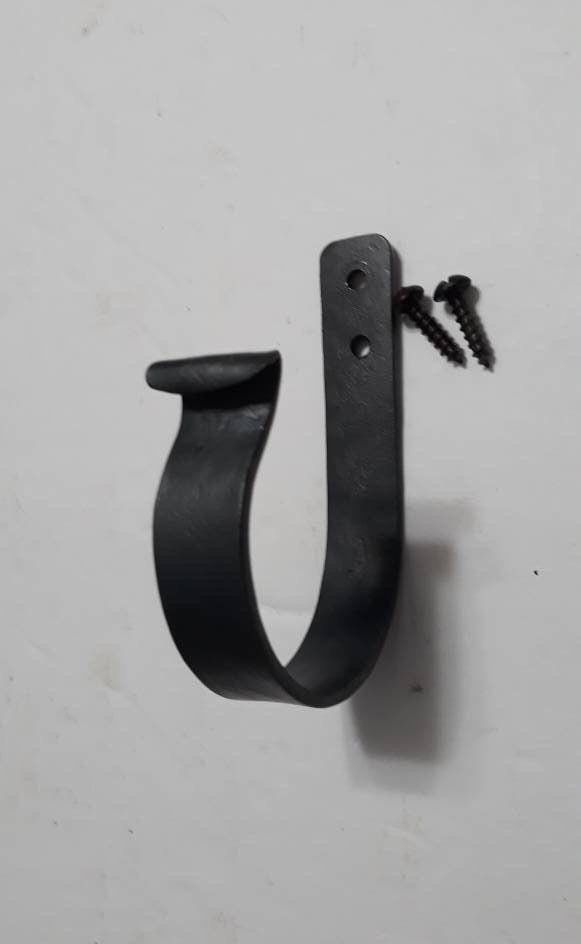 a black hook with two screws attached to it's side on a white wall