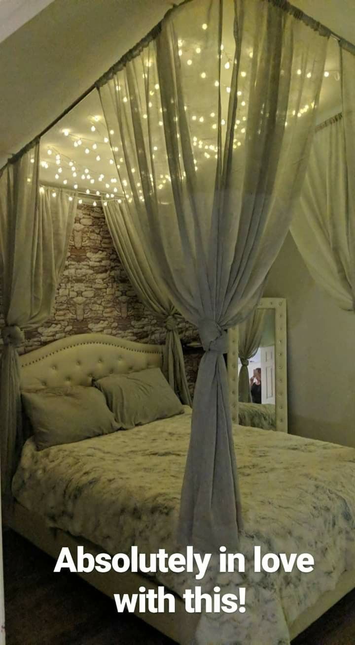 an image of a bedroom setting with lights on the ceiling and canopy over the bed