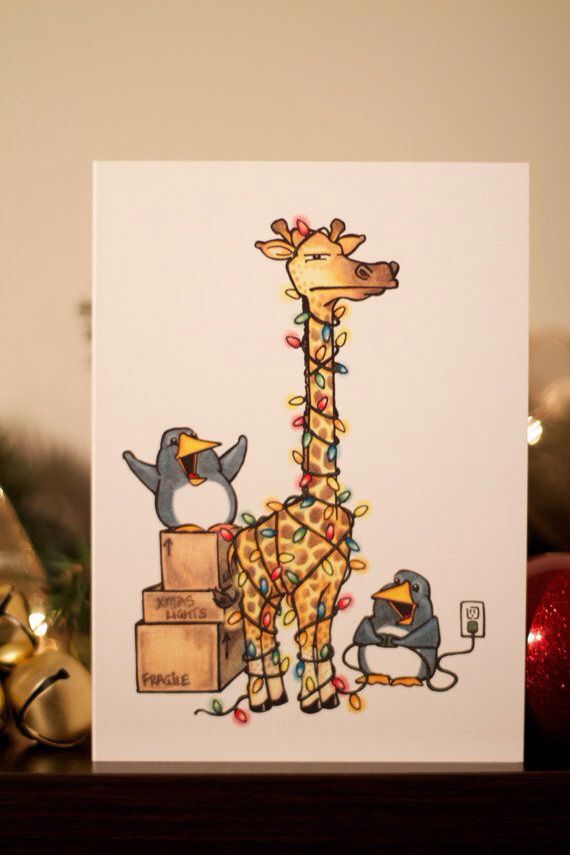 a giraffe standing next to two birds on top of a wooden box with christmas lights