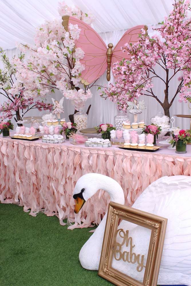 the table is set up with pink flowers and umbrellas