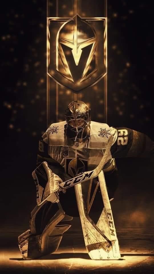 an ice hockey goalie kneeling down in front of a golden emblem