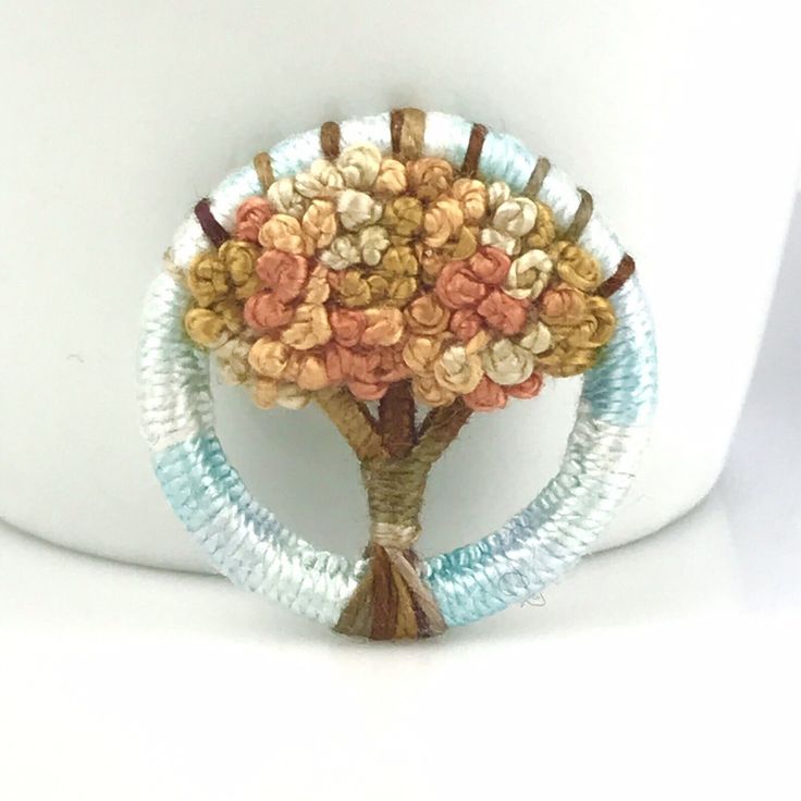 a white vase with a tree made out of beads