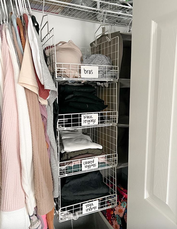 an organized closet with clothes and hats hanging on the rack, next to a door