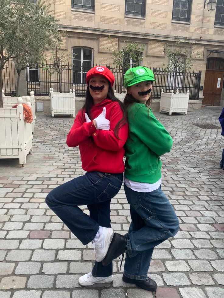 two people are posing for the camera in front of a building