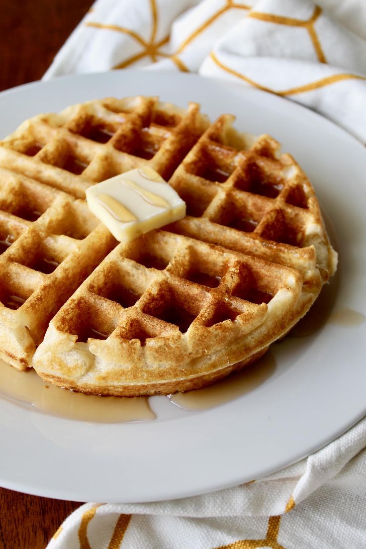 a white plate topped with waffles and butter