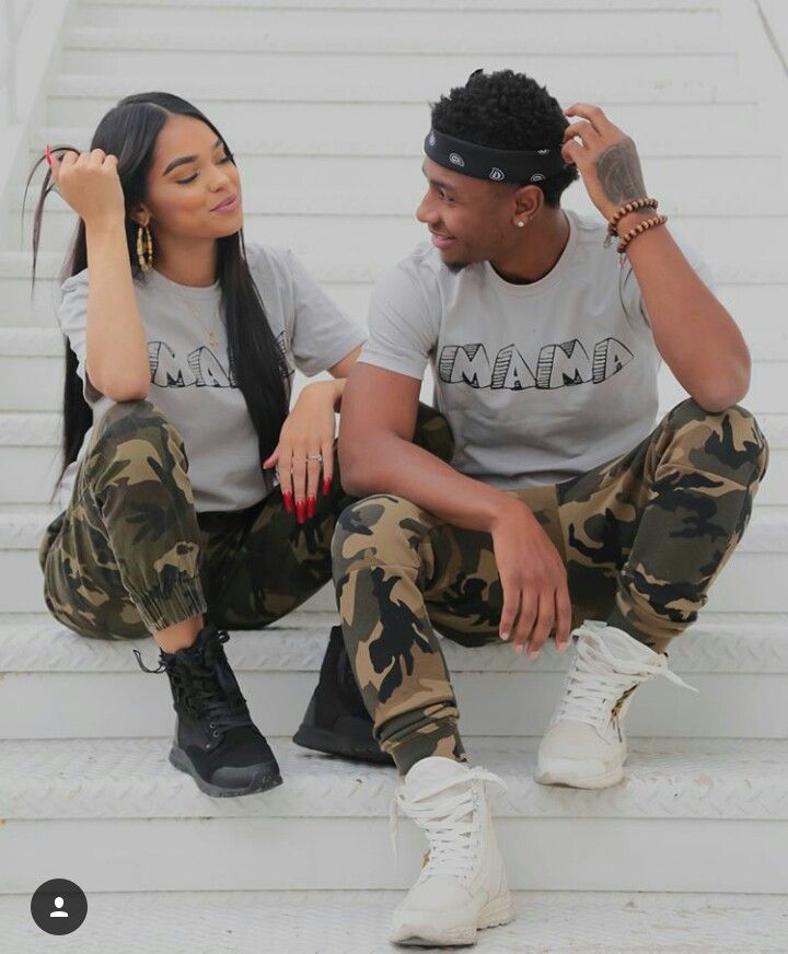 a man and woman sitting on the steps with their fingers up to their mouths as they look at each other