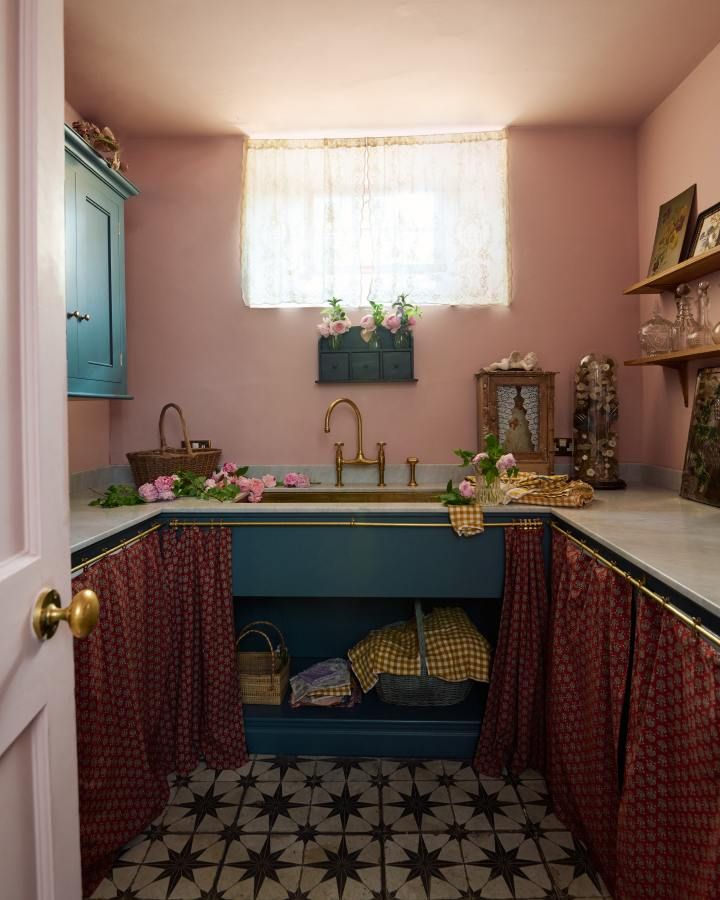 a kitchen with pink walls and black and white flooring