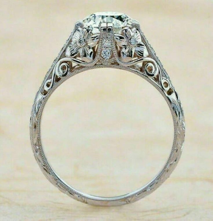 an antique style diamond engagement ring with filigrees