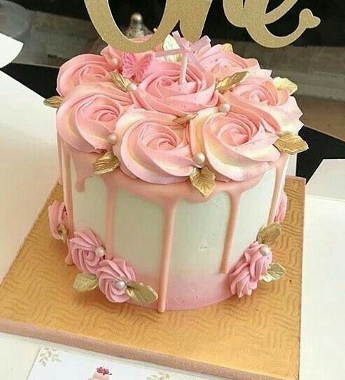 a cake with pink frosting and gold decorations