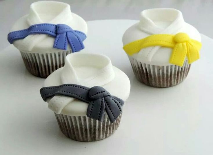 three cupcakes with bows on them sitting on a table