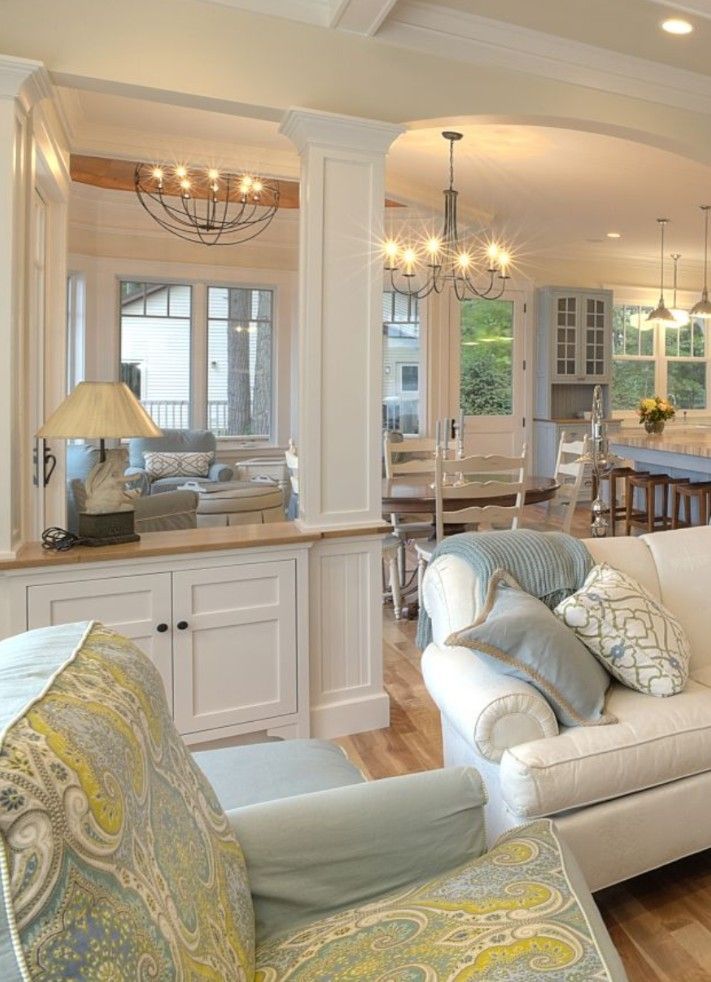 a living room filled with furniture next to a kitchen