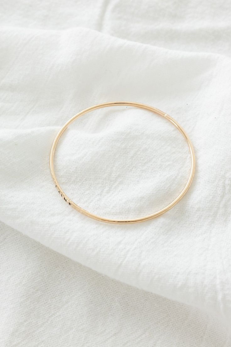 14k gold filled 2mm hammered textured bangle Please note: this bangle is hand-stamped so the stamping may not be perfect If you would like a different length that is not listed, please contact us for a custom order! Finding Your Size We recommend using a flexible measuring tape to wrap around your wrist to find the length of your preferred fit. An alternative to this is getting a piece of string or shoelace, wrap that around your wrist, and measure the length in inches Everyday 14k Gold Hoop Bracelets, Hammered Yellow Gold Bangle For Everyday, Everyday Hammered Yellow Gold Bangle, Everyday 14k Gold-filled Bangle Bracelet, Everyday 14k Gold Filled Bangle Bracelet, Dainty Rose Gold Everyday Bangle, Gold Hand Stamped Bangle Bracelets, Hand Stamped Gold Bangle Bracelets, Hand Stamped Gold Bangle Bracelet