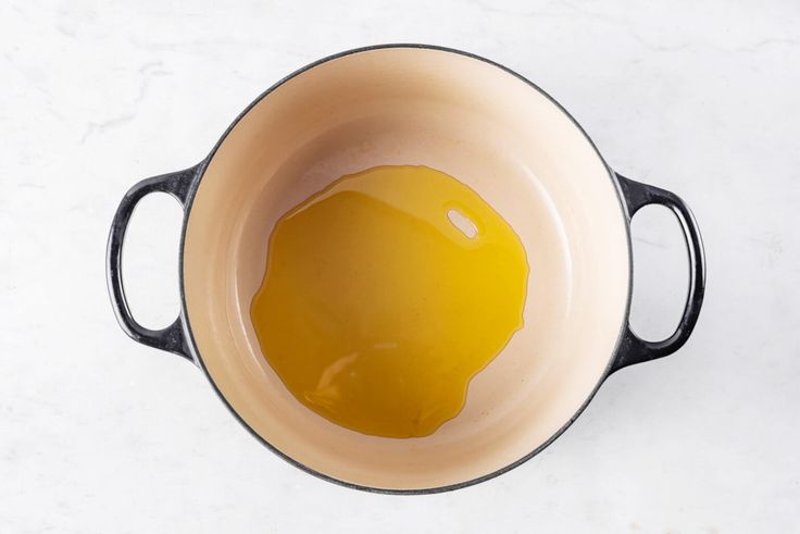 an egg is in a saucepan on a white counter top with a black handle