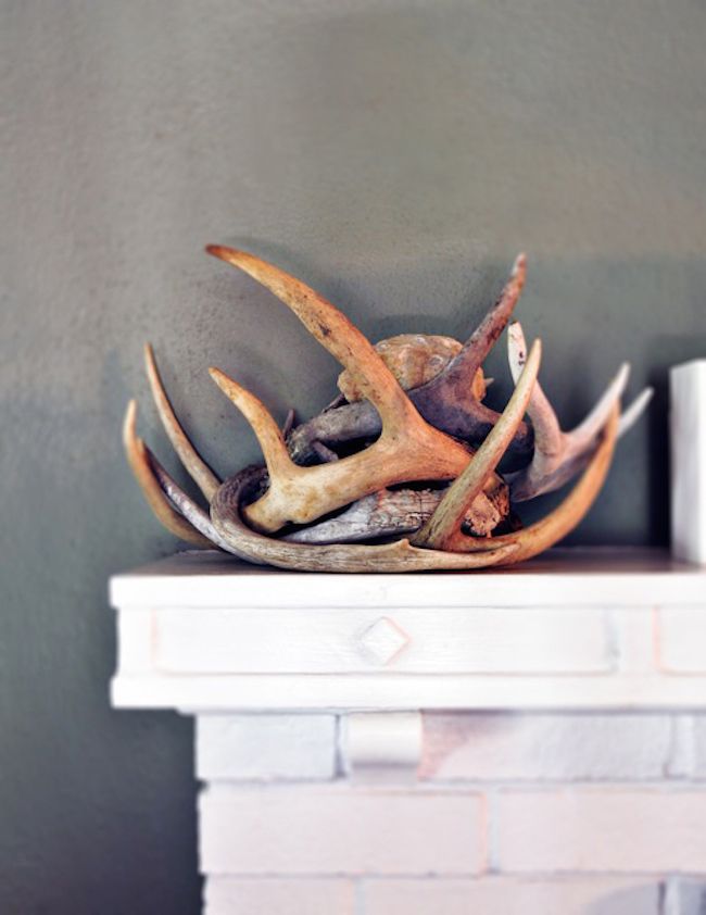 an antlers head on top of a fireplace mantel