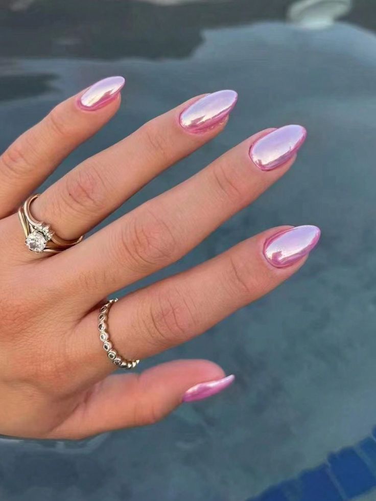 a woman's hand with pink and white manies on it, wearing a diamond ring