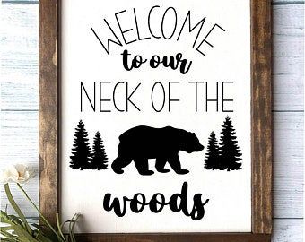 a sign that says welcome to our neck of the woods with a bear and trees