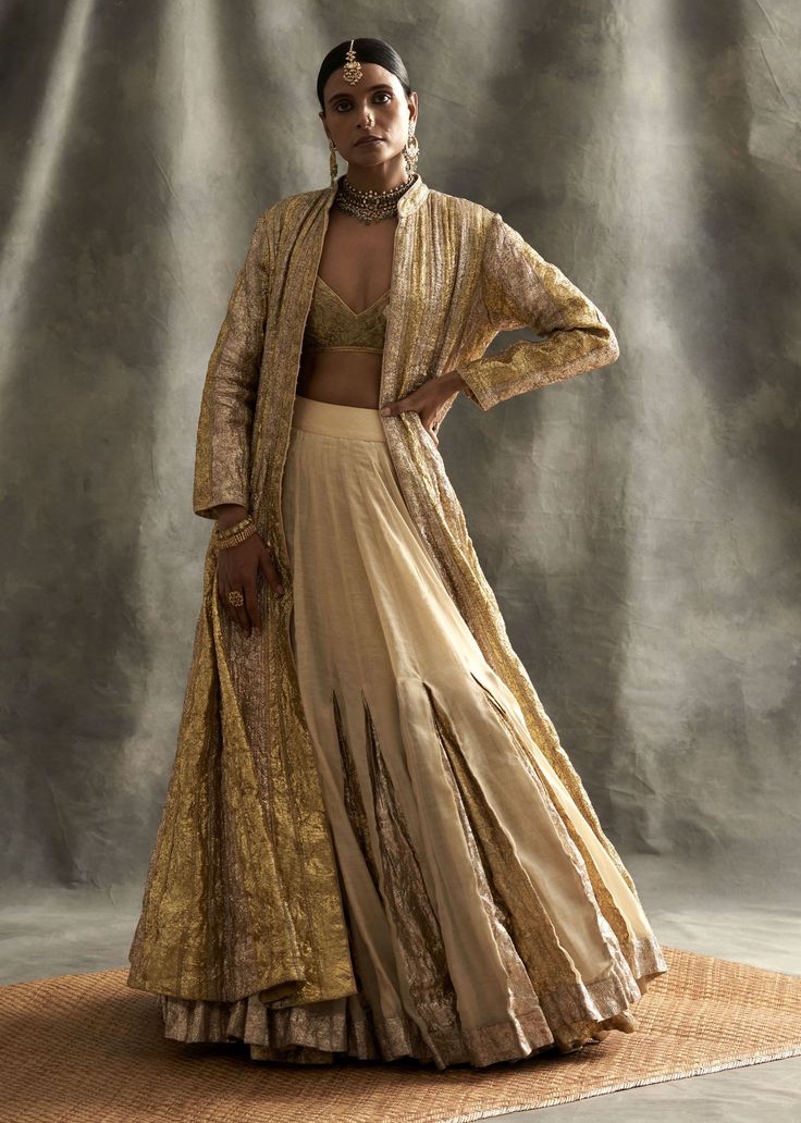 Editor's Note Silver Gold Striped Ghera Lampi Jacket With Gold Chanderi, Metallic Godet Inserts Double Tier Skirt. The Blouse Is Made Out Of Gold Lampi. Fabric: Chanderi Color: Gold Silver Care: Dry Clean Only About the Designer Itrh makes a high-end luxury Indian ethnic wear made using exquisite and endangered age-old crafts such as kalamkari, madhubani, chikankari, zardozi, and gota weaving. The focus of the house is to cherish the beauty of handcrafted luxury designer wear. Grey Lengha, Jacket With Skirt, Jacket Lehenga, Indian Groom Wear, Godet Skirt, Silver Jacket, Gold Jacket, Desi Aesthetic, Indian Clothes