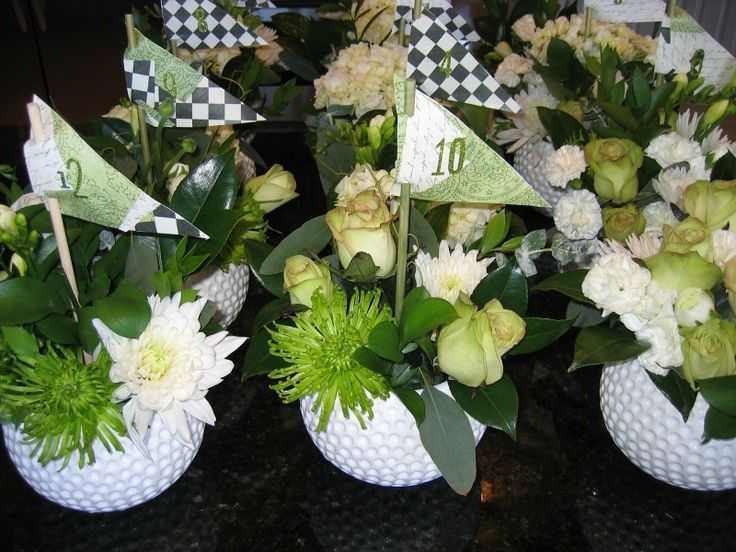 there are many vases with flowers and flags in them on the table together,