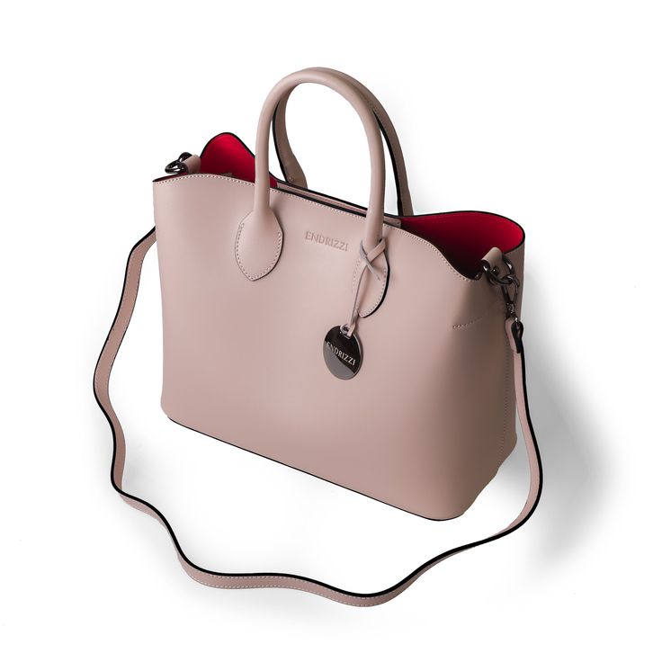 The Jessica Mae tote bag( named after an Endrizzi Founder) is part of our core line of products. It's a minimalist, chic and trendy, tote-style handbag that is built for power females. It features a contrasting red interior which makes this nude tote bag stand out from the crowd. The Jessica Mae is both trendy and classic - an easy choice for everyday use and a busy lifestyle. Safety Safety is also top of mind in this tote bag. The main compartment is closed by a double set of magnetic locks, wh Modern Blush Bag With Removable Pouch, Modern Pink Top Handle Bag, Modern Blush Rectangular Bag, Modern Blush Bag For Everyday Use, Modern Pink Tote Satchel, Modern Pink Bag With Detachable Handle, Blush Bag With Detachable Strap For Everyday, Everyday Blush Bag With Detachable Strap, Blush Satchel With Detachable Strap For Daily Use