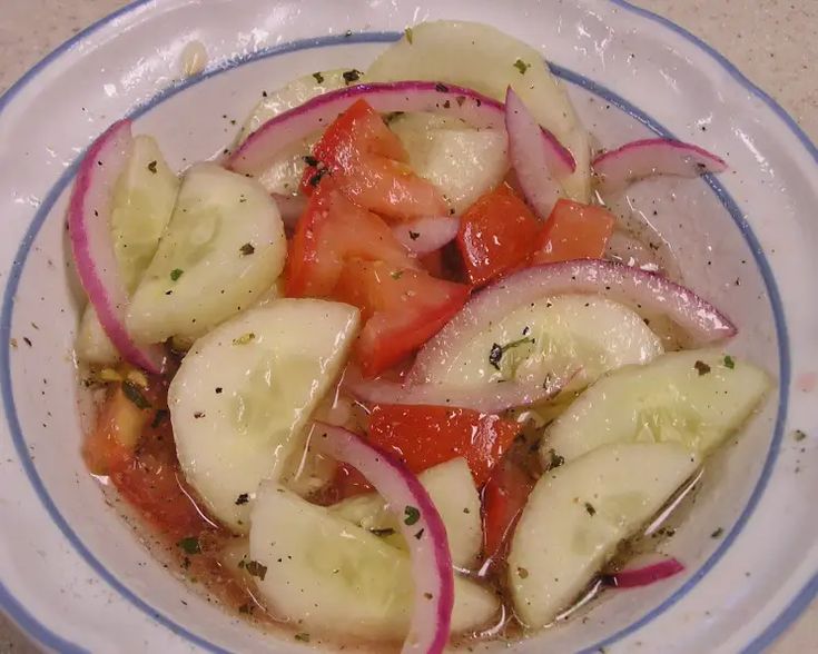 a bowl filled with sliced up vegetables on top of a table