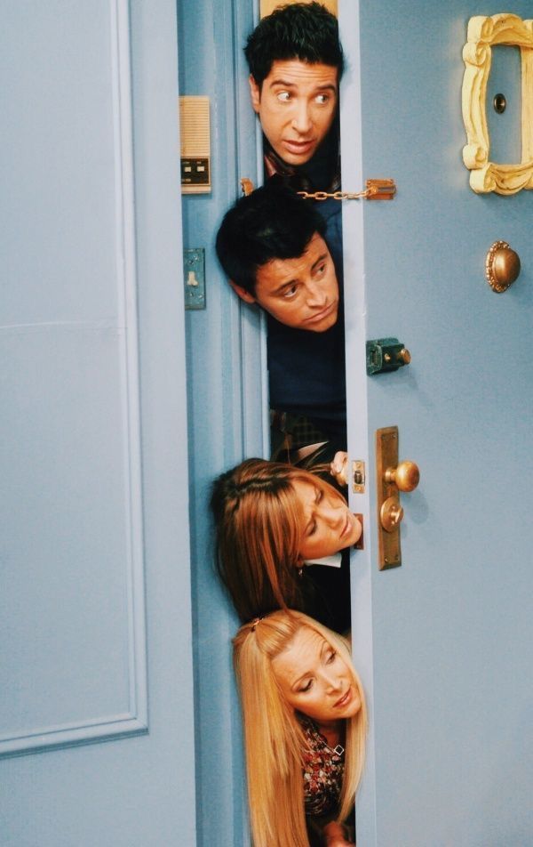 the cast of friends hanging out in front of a blue door with their heads sticking out