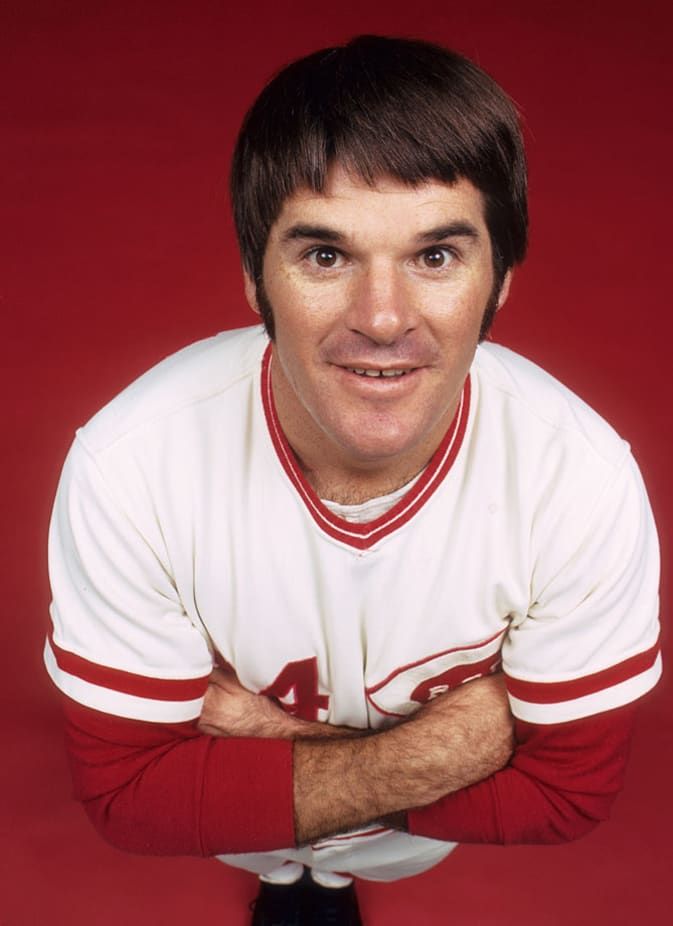 a baseball player posing for a photo with his arms crossed