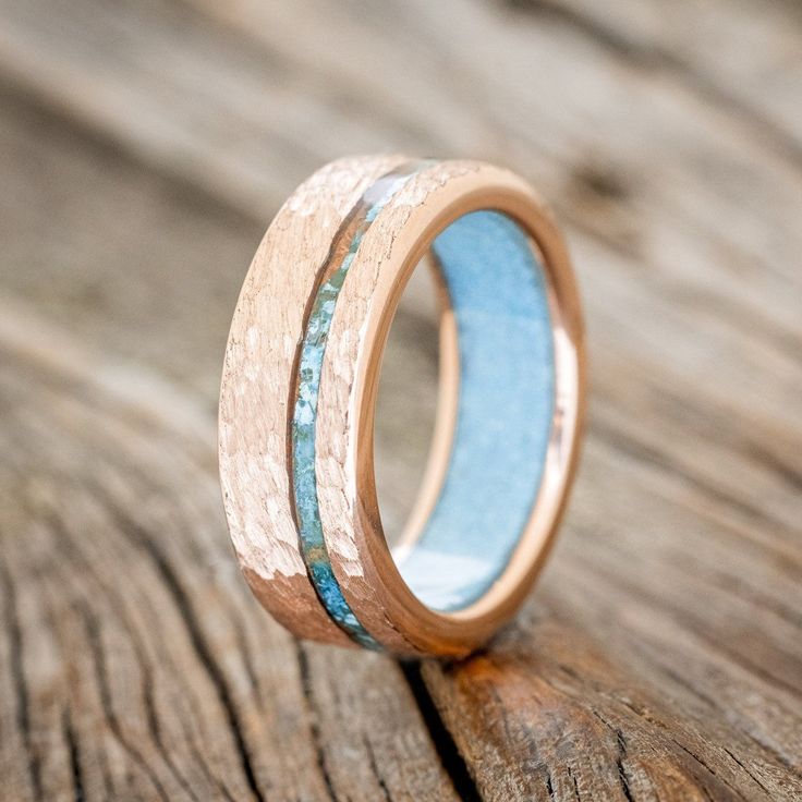 a wooden ring with blue and gold inlays