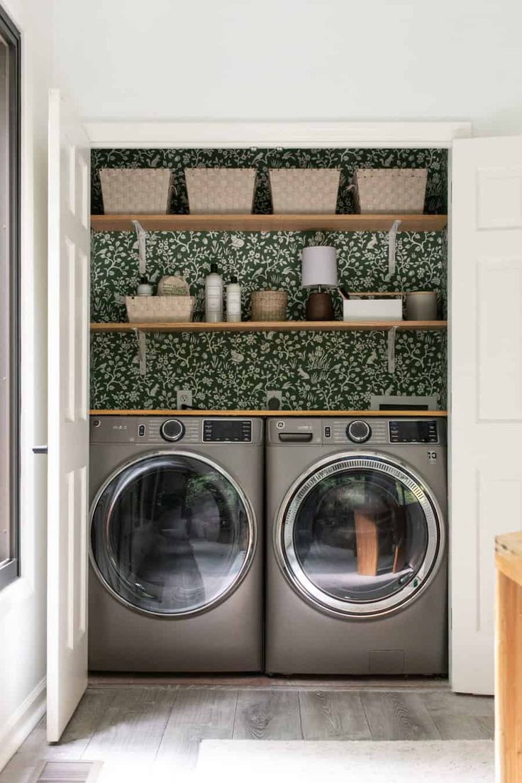 a washer and dryer in a room with green wallpaper on the walls