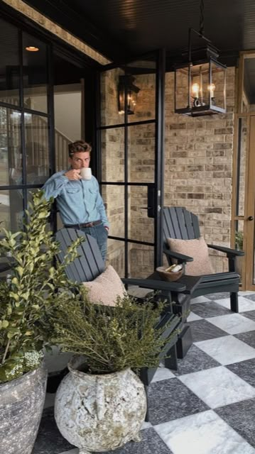 a man sitting on top of a chair next to two planters filled with plants