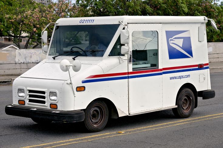 an postal truck is driving down the street