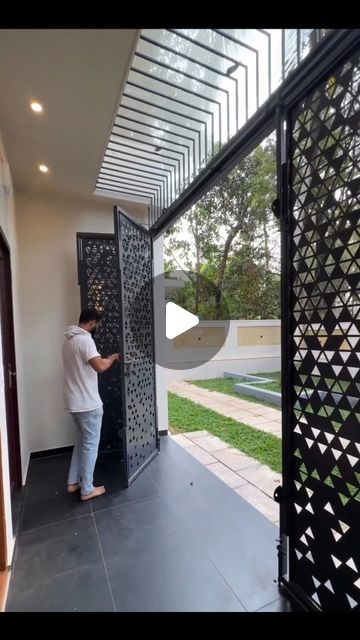 a man is opening the door to his house with an iron screen on it's side