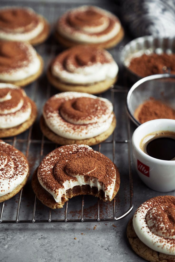 some cookies are cooling on a rack with powdered sugar and coffee in the background