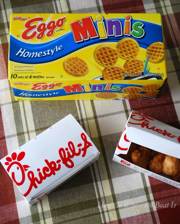 two boxes of eggs and waffles sitting on top of a table with a checkered cloth