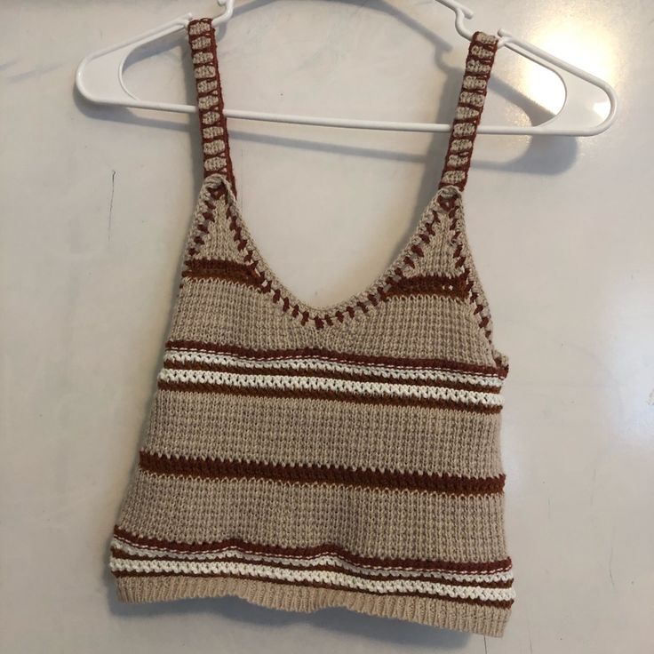 a knitted tank top hanging on a hanger