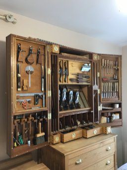 a wooden cabinet filled with lots of tools