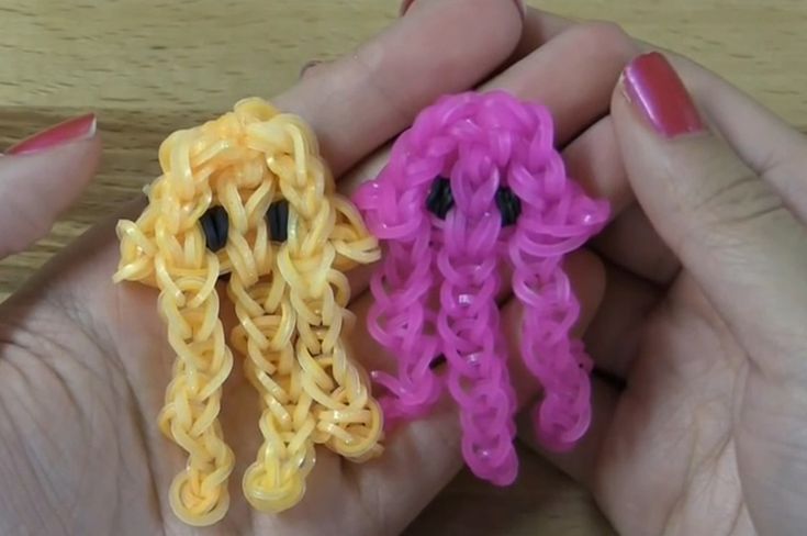 two handmade items in the palm of someone's hands with pink and yellow hair