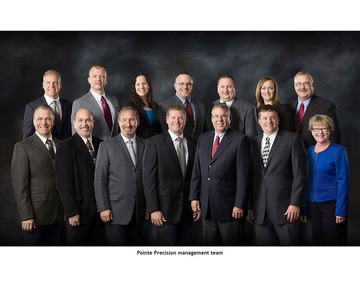 a group of people in suits and ties posing for a photo