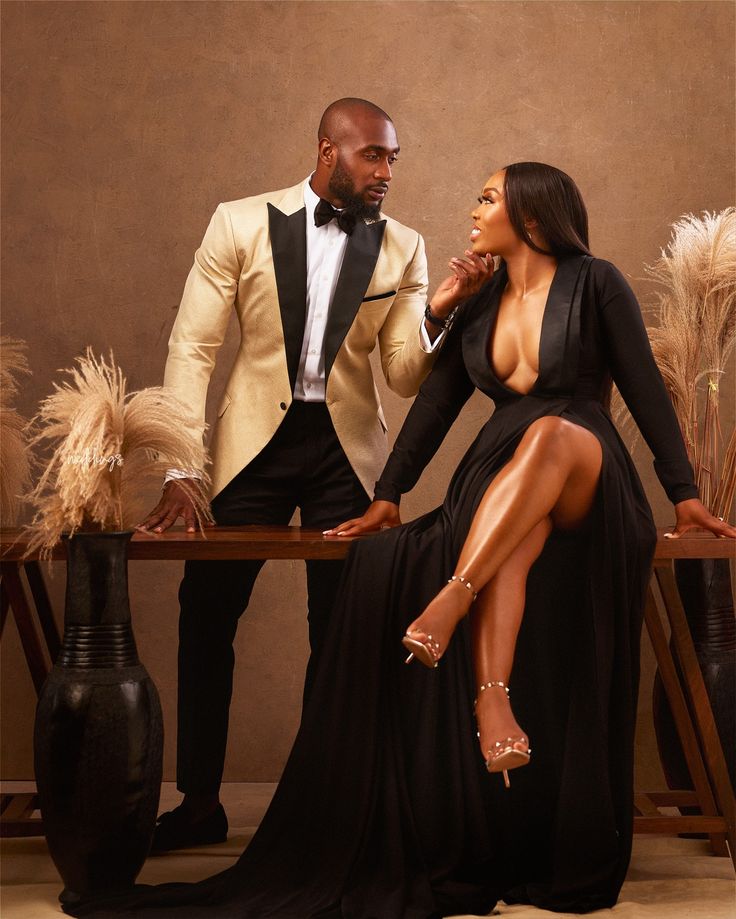 a man in a tuxedo sitting next to a woman wearing a black dress