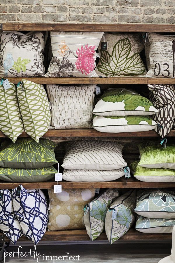 the shelves are filled with pillows and throw pillows in different colors, patterns and sizes