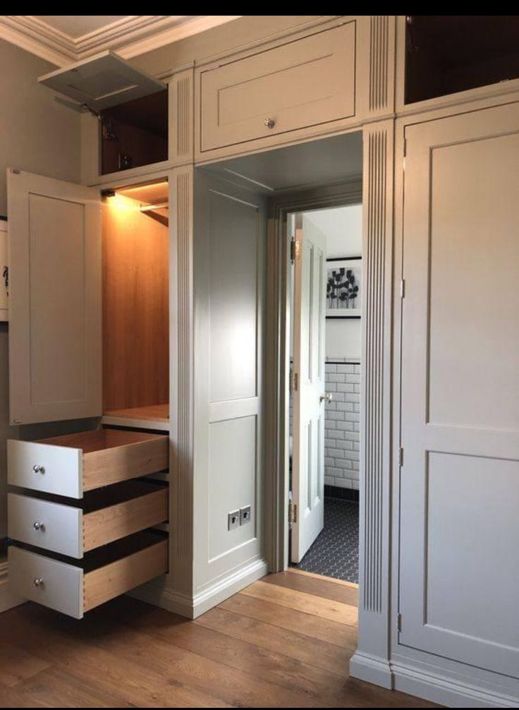 an empty kitchen with white cabinets and drawers