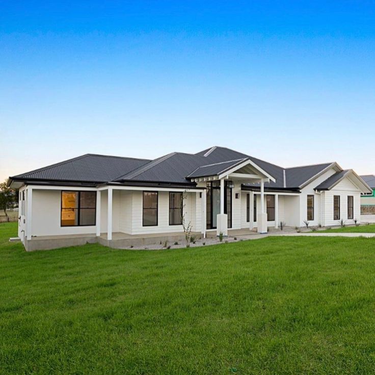 a white house sitting on top of a lush green field