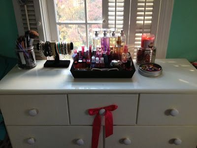 a white dresser topped with lots of cosmetics