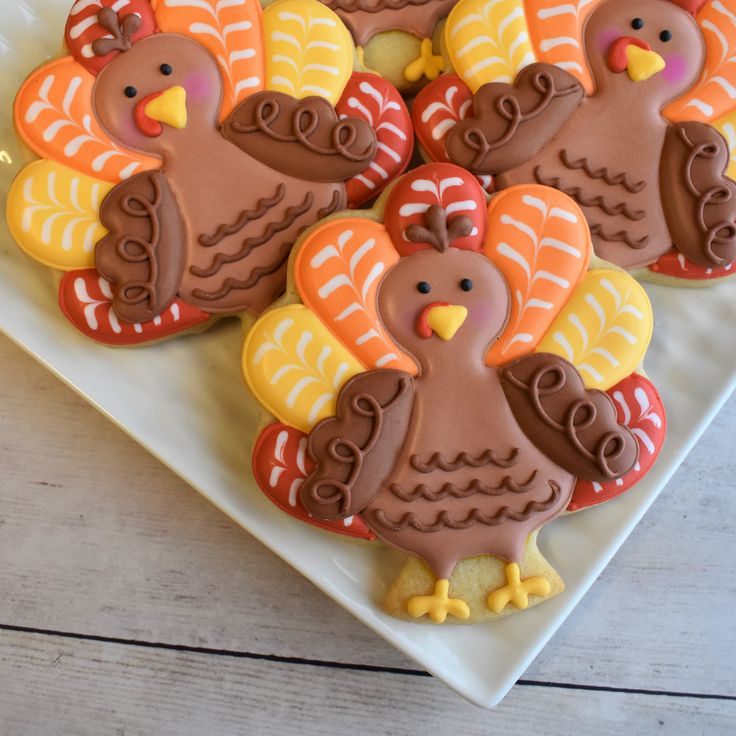 decorated cookies in the shape of turkeys on a plate