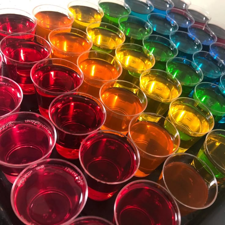 there are many different colored cups in the tray