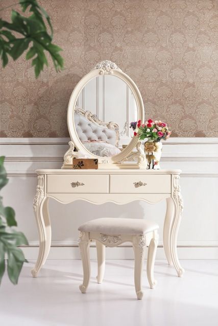 a white dressing table with a mirror and stool