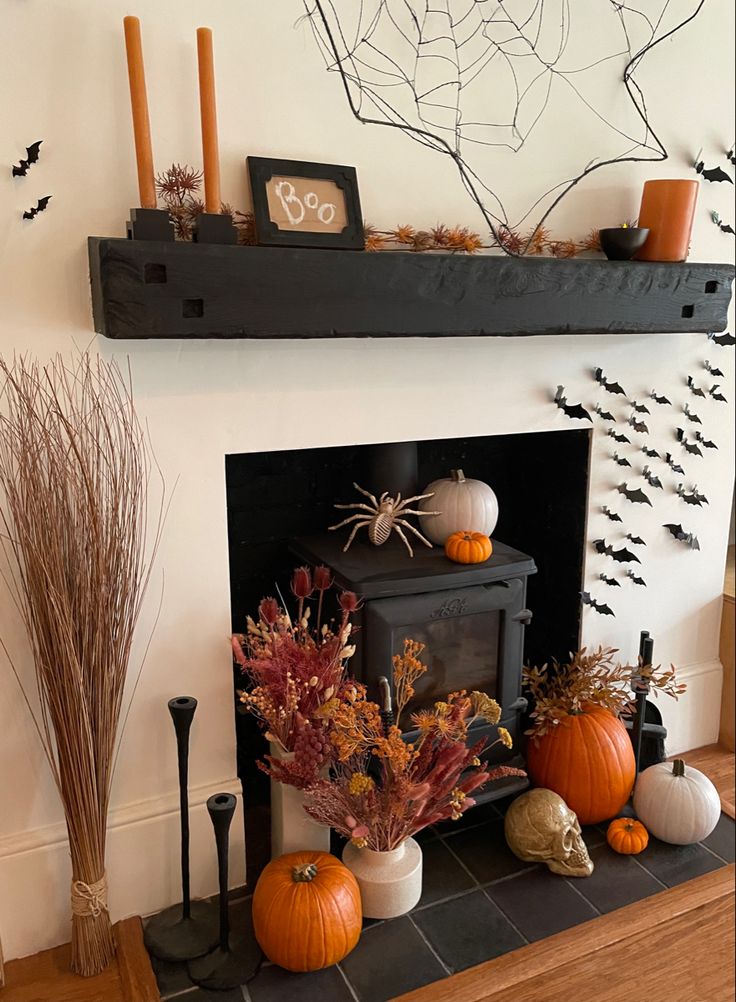 a fireplace decorated for halloween with pumpkins and other decorations