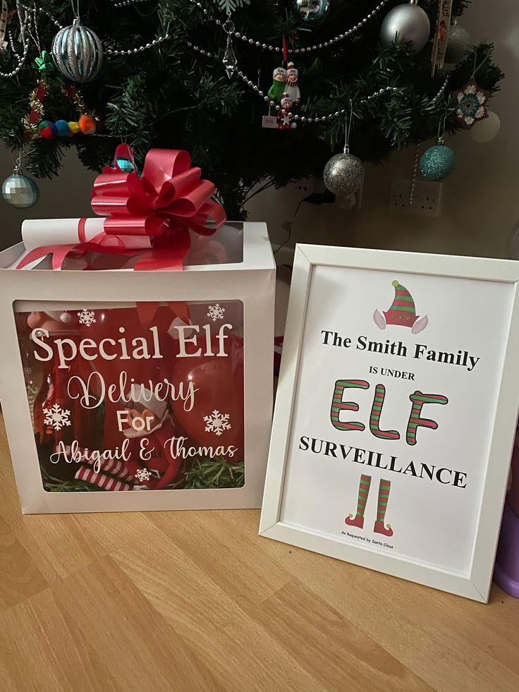 two gift boxes sitting on top of a wooden table